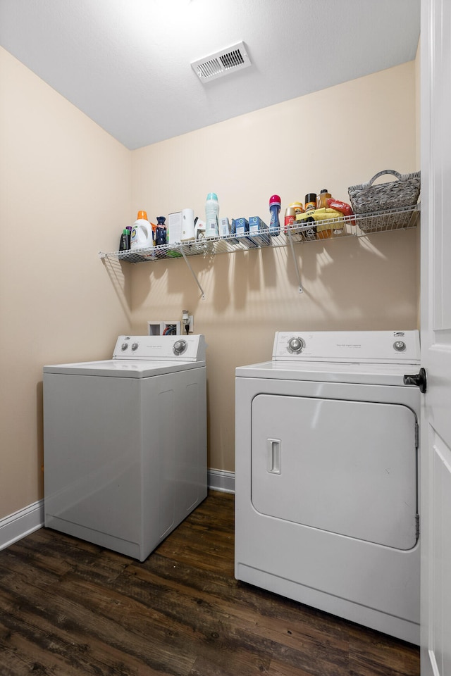 clothes washing area with dark wood-type flooring and washer and dryer