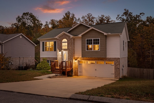 bi-level home featuring a garage and a lawn