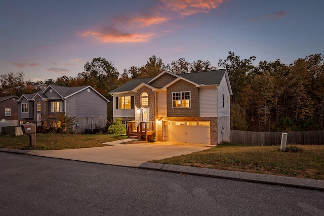 raised ranch with a garage and a yard