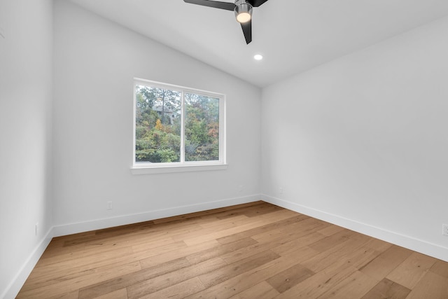 spare room featuring light wood-type flooring, lofted ceiling, and ceiling fan