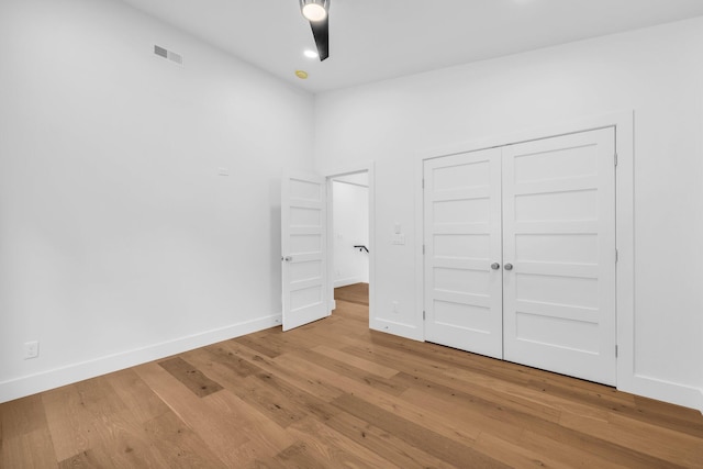 unfurnished bedroom with light hardwood / wood-style floors and a closet