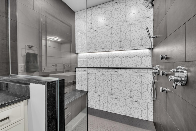 bathroom with tile walls, vanity, and a shower