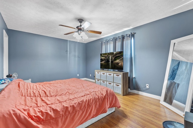 bedroom with wood-type flooring, a textured ceiling, and ceiling fan