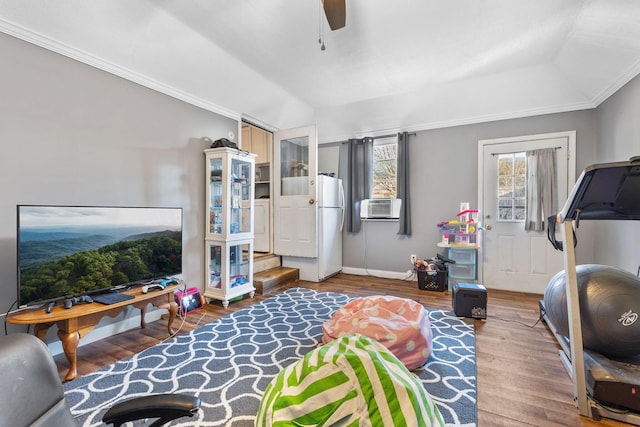 interior space with cooling unit, hardwood / wood-style flooring, ceiling fan, a tray ceiling, and crown molding