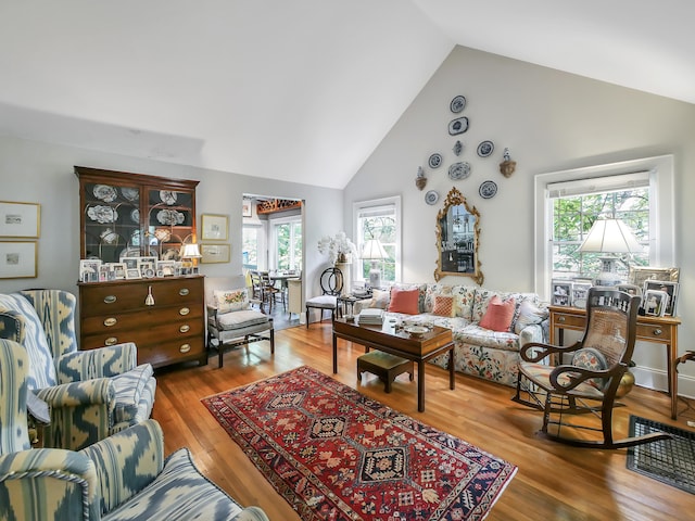 living room with high vaulted ceiling and hardwood / wood-style flooring