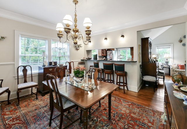 dining room featuring ornamental molding, lofted ceiling, an inviting chandelier, and dark hardwood / wood-style floors