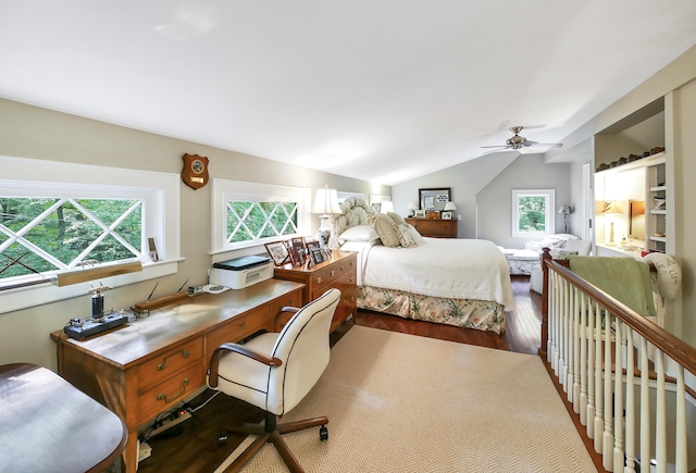 bedroom with hardwood / wood-style floors, ceiling fan, built in desk, and vaulted ceiling