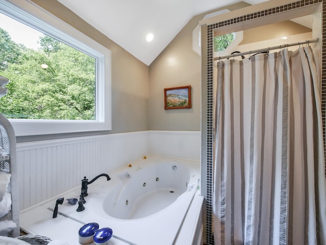 bathroom featuring independent shower and bath and lofted ceiling