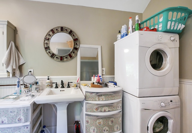 clothes washing area featuring stacked washer / drying machine