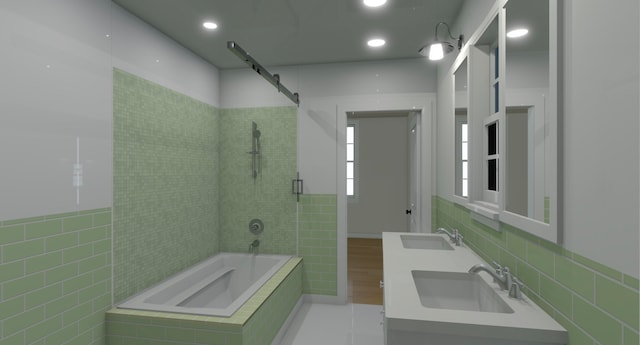 bathroom with vanity, tile walls, and tiled shower / bath