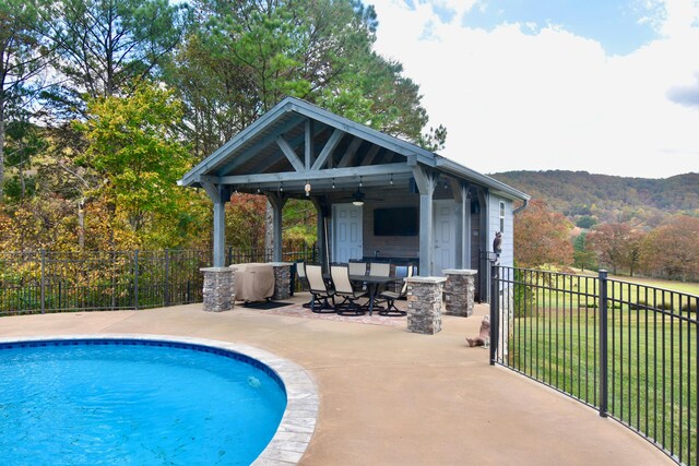 view of pool featuring a mountain view, a patio, a yard, and a gazebo