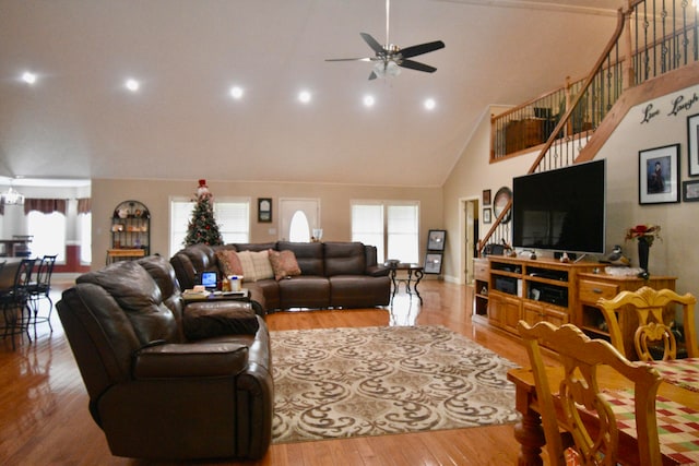 living room featuring light hardwood / wood-style floors, ceiling fan, and high vaulted ceiling