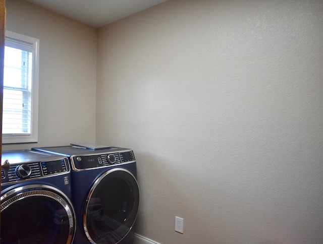 clothes washing area with a wealth of natural light and washer and clothes dryer