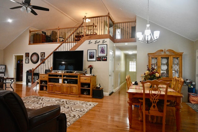 living room featuring high vaulted ceiling, hardwood / wood-style flooring, and ceiling fan with notable chandelier