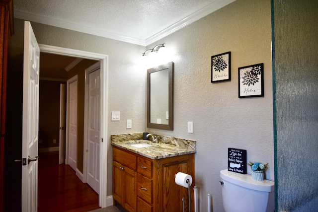 bathroom featuring ornamental molding, hardwood / wood-style floors, vanity, and toilet