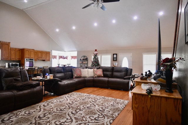 living room featuring ceiling fan, light wood-type flooring, and high vaulted ceiling