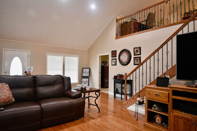 living room featuring high vaulted ceiling and light hardwood / wood-style floors