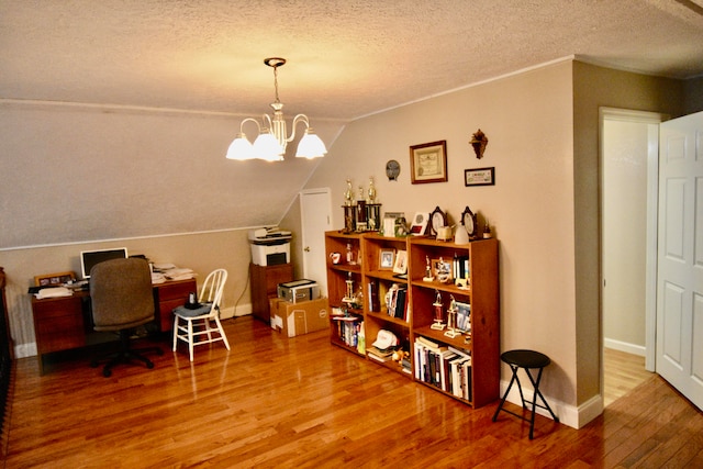 dining space featuring hardwood / wood-style floors, a textured ceiling, vaulted ceiling, and a notable chandelier