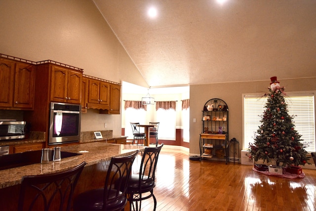 334 Belaire Dr, Copperhill, TN 37317 - kitchen with stainless steel appliances, brown cabinets, plenty of natural light, wood-type flooring, and a textured ceiling
