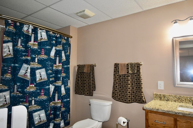 bathroom with vanity, a paneled ceiling, and toilet