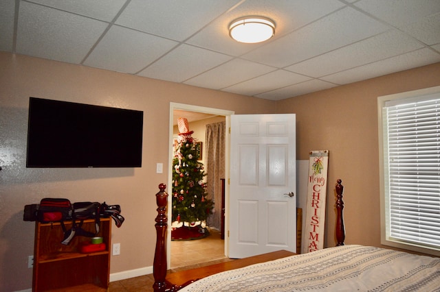 bedroom featuring a drop ceiling and tile patterned flooring