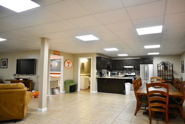 dining space featuring a drop ceiling and light tile patterned flooring