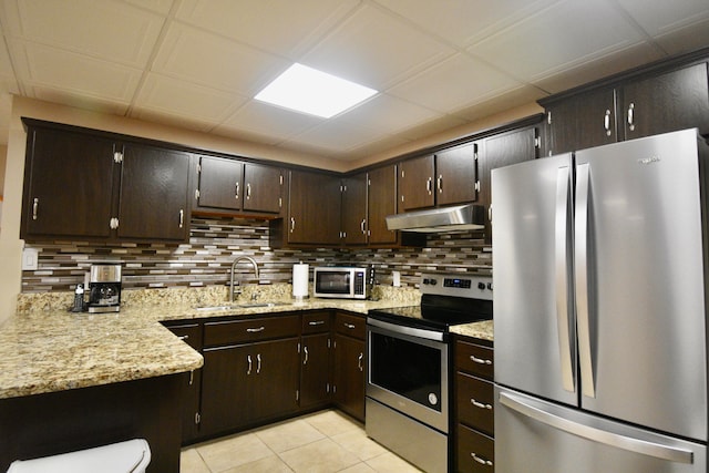 kitchen featuring stainless steel appliances, dark brown cabinets, sink, and decorative backsplash