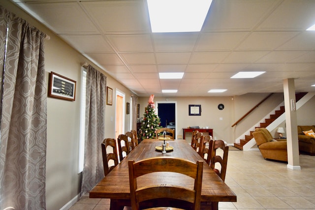 dining room featuring a drop ceiling and light tile patterned flooring