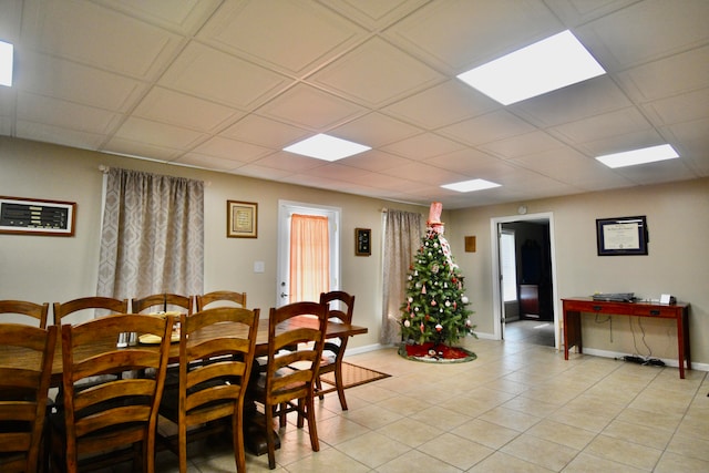 dining room featuring a paneled ceiling and light tile patterned flooring