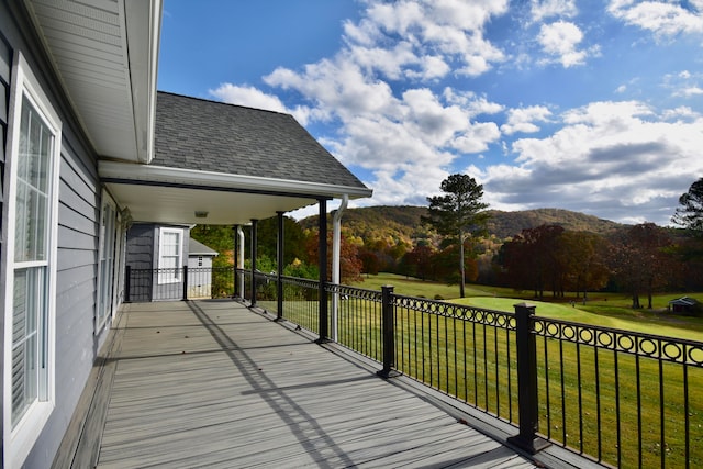 deck with a yard and a mountain view