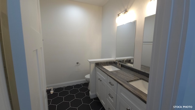 bathroom with tile patterned flooring, vanity, and toilet