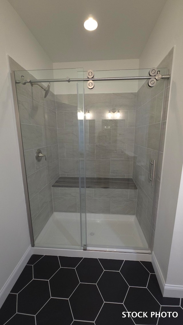 bathroom with an enclosed shower and tile patterned flooring