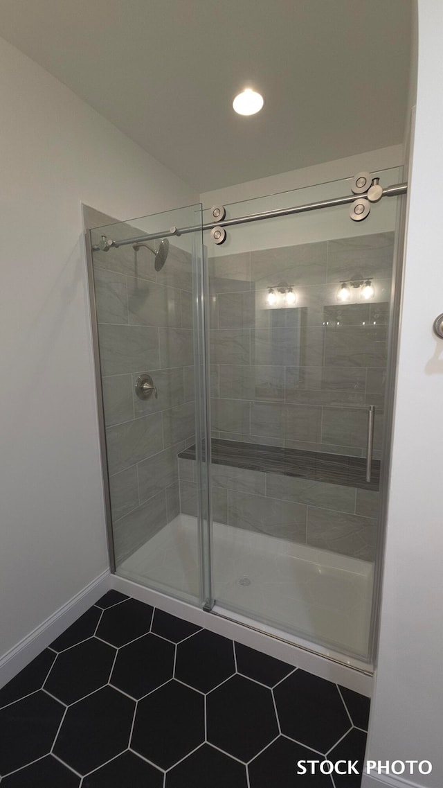 bathroom with a shower with door and tile patterned flooring