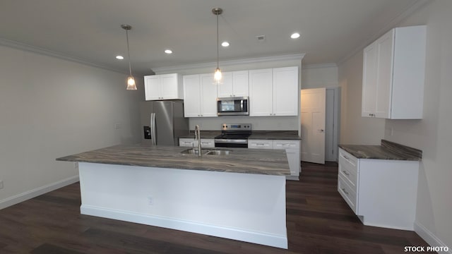 kitchen with a center island with sink, sink, appliances with stainless steel finishes, decorative light fixtures, and white cabinets