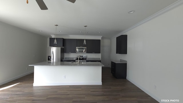 kitchen with stainless steel appliances, light stone countertops, an island with sink, and decorative light fixtures