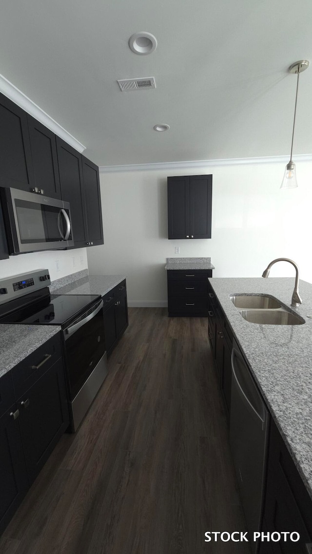 kitchen featuring stainless steel appliances, sink, light stone countertops, dark hardwood / wood-style floors, and hanging light fixtures