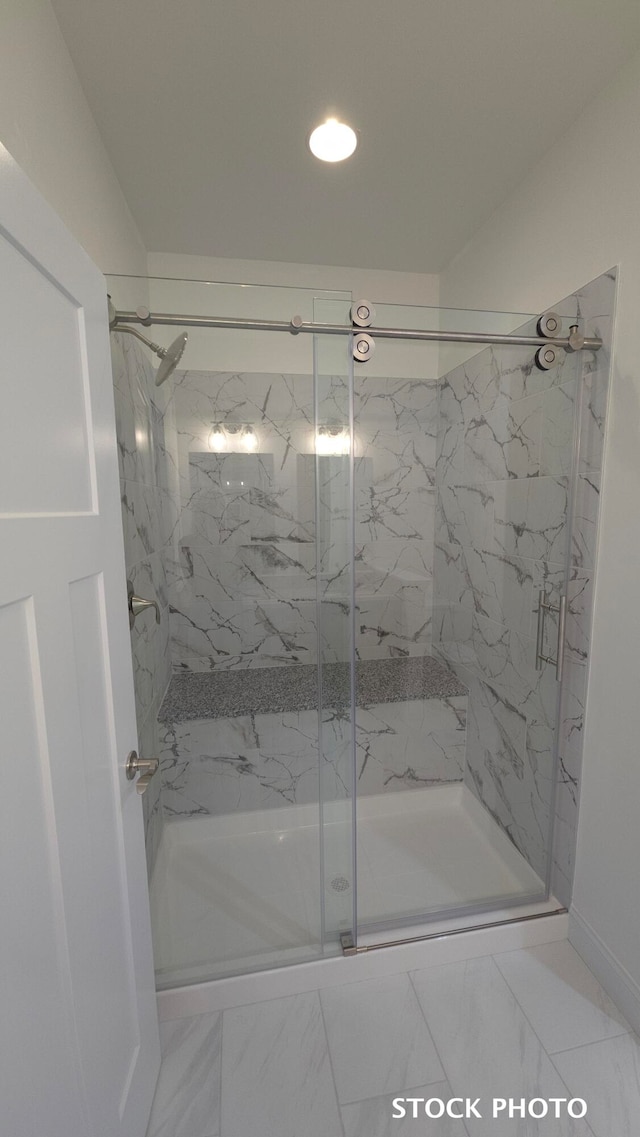 bathroom featuring a shower with door