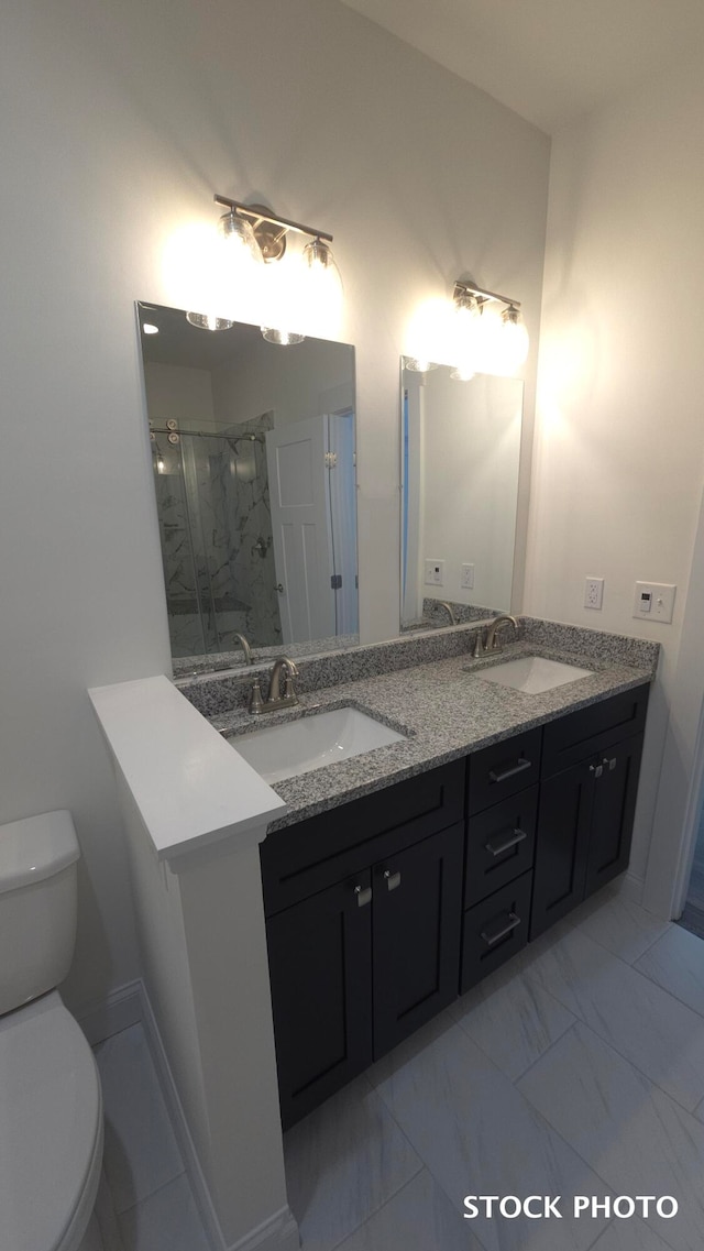 bathroom with a shower with door, vanity, and toilet