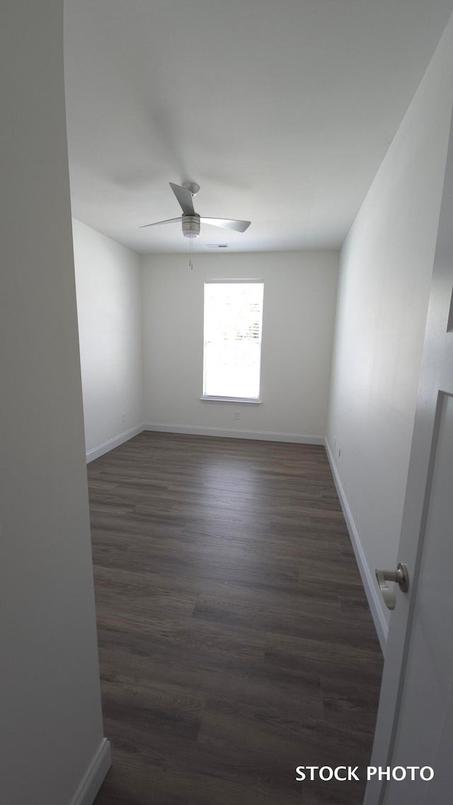 unfurnished room featuring dark wood-type flooring and ceiling fan