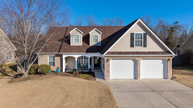 cape cod house with a garage and covered porch