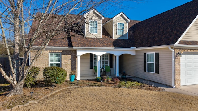 cape cod-style house featuring a porch and a garage