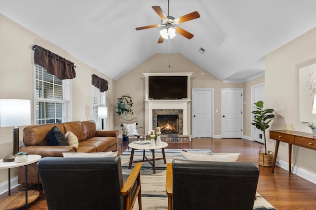 living room featuring vaulted ceiling, hardwood / wood-style floors, ceiling fan, and a fireplace