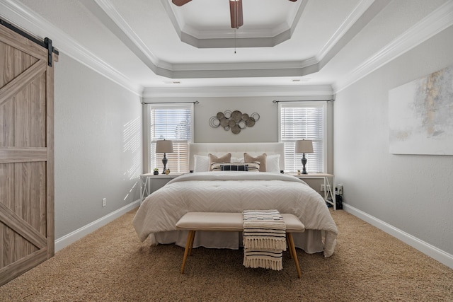 bedroom with carpet flooring, ceiling fan, a tray ceiling, crown molding, and a barn door