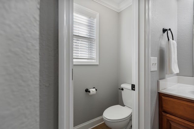 bathroom with ornamental molding, toilet, and vanity