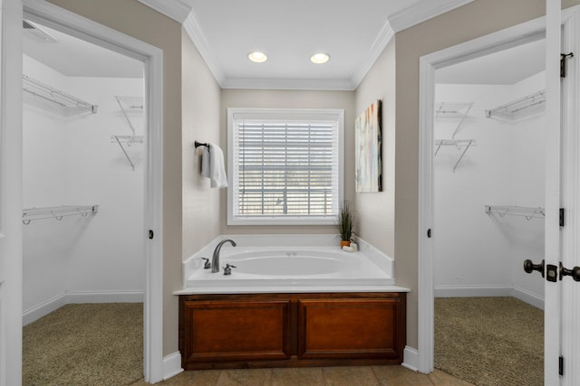 bathroom featuring ornamental molding and a tub