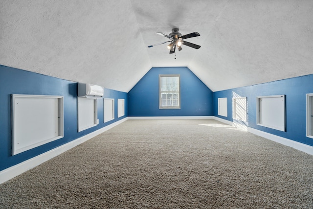 additional living space featuring lofted ceiling, a wall mounted air conditioner, ceiling fan, and carpet flooring