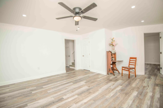 spare room with ceiling fan and light wood-type flooring