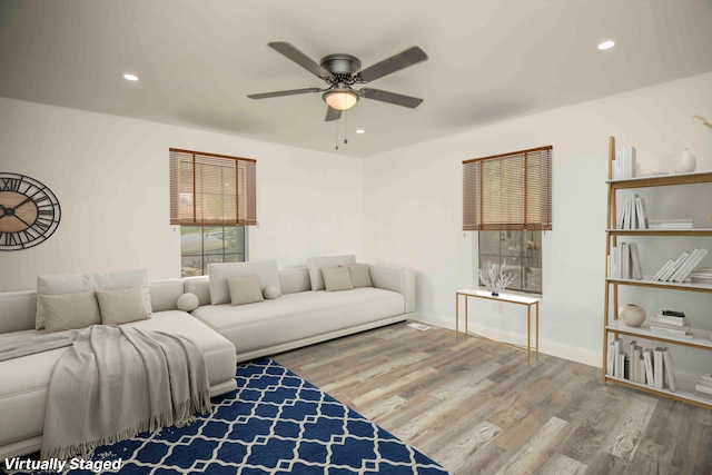 living room with wood-type flooring and ceiling fan