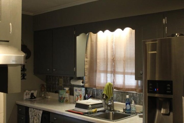 kitchen featuring stainless steel refrigerator with ice dispenser, ornamental molding, backsplash, and exhaust hood