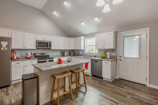 kitchen with white cabinetry, stainless steel appliances, dark hardwood / wood-style floors, and a center island